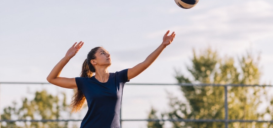 Volleyball player practicing an overhand serve toss